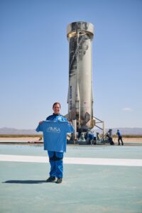 Gretchen Green holding vintage IMSA t-shirt in front of space shuttle